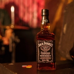 A bottle of Jack Daniels on a bar.