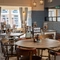 An interior restaurant seating area at The Cherry Tree; with upholstered booth seating, and large windows.