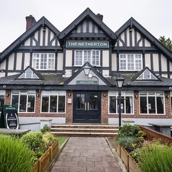 Exterior facade of a pub with a seating area.