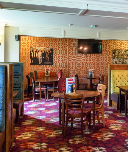 Interior dining area of a pub with a TV.