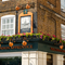 A close up view of the exterior facade and signage of The London Apprentice, with planter boxes filled with flowers above the golden yellow lettering spelling "The London Apprentice" on two sides of the pub.