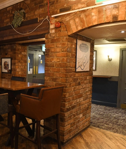 Interior dining area of a pub with a TV.