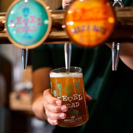 A close up image of a pint of Level Head being poured behind the interior bar at a Community Pubs With Food venue.