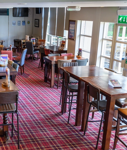 Interior dining area of a pub with a few TVs.