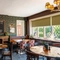 An interior restaurant seating area at The Walkford, with a padded bench seat next to the leaded windows, and a fireplace.