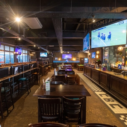 The interior bar and restaurant seating area with many TV screens at The Cold Beer Company.