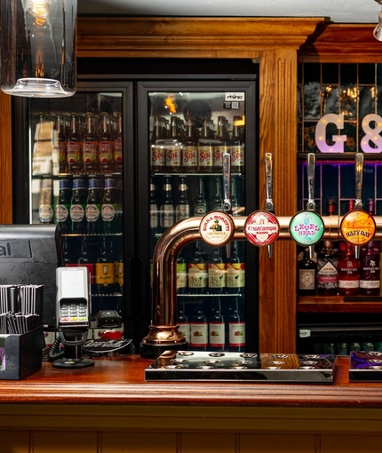 A close up view of the beer taps on the bar inside The White Hart in Frimley.