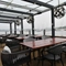 Exterior seating area of a pub next to a body of water.