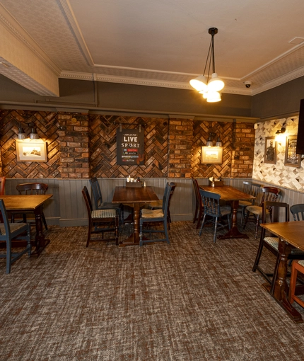 Interior dining area of a pub with a TV.