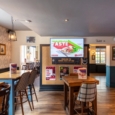 The interior restaurant seating area with TV at The Wheatsheaf.