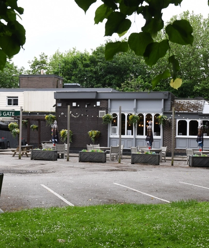 Exterior facade and beer garden of a pub with a seating area.