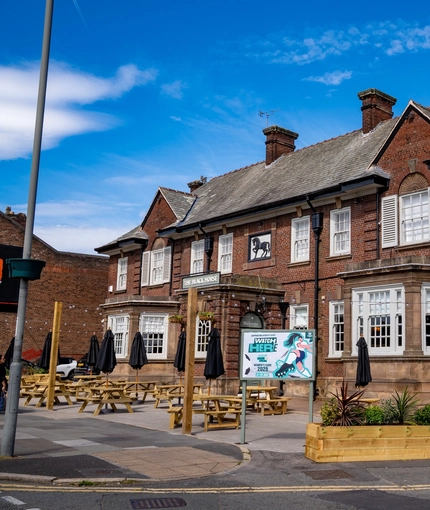 The exterior facade with signage and seating area at the Black Horse.