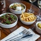 Selection of plates from the spring menu, plated and arranged on a wooden table