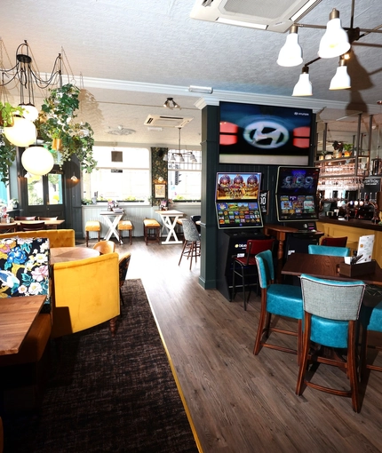 An interior shot of the main seating area, pub games & bar at The Palmeira in Hove.