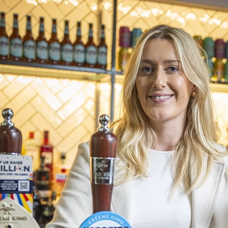 A woman standing behind a bar.