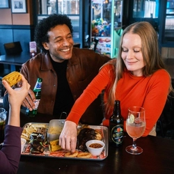 A family enjoying a meal and drinks in the interior restaurant from the new Spring/Summer menu at Flaming Grill.