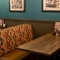 An interior restaurant seating area at The Tamar, with upholstered booth seats, and framed artwork on the wall.