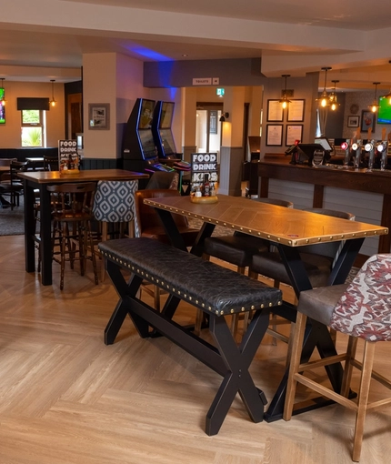 The bar and interior restaurant seating area at The Wall's End, with TVs on the walls, and gaming machines.