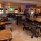 The bar and interior restaurant seating area at The Wall's End, with TVs on the walls, and gaming machines.