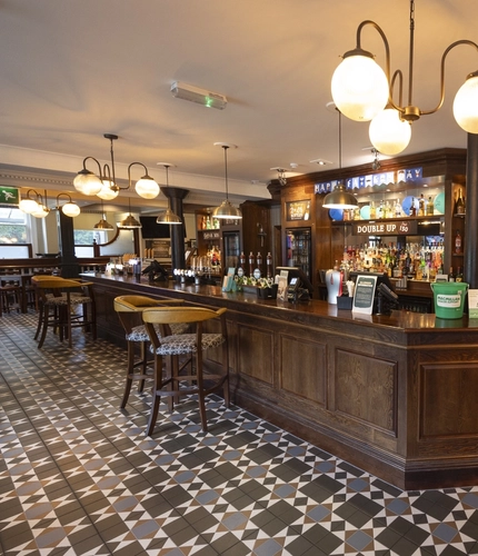 Interior bar area of a pub with stools.