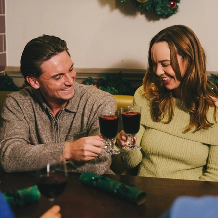 An image of a group of friends enjoying various drinks within the interior seating area at a Greene King venue.