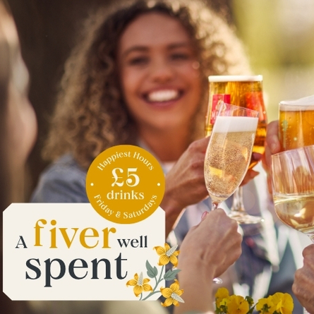 A group of friends clink glasses filled with beer, wine, and prosecco outdoors on a sunny day. Everyone is smiling and celebrating. A promotional graphic in the corner reads: ‘A fiver well spent – £5 drinks. Happiest Hours, Friday & Saturdays,’ decorated with small yellow flowers available at Chef and Brewer venues.
