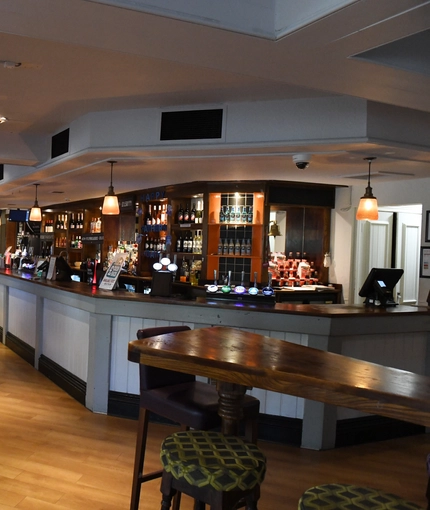 Interior dining area of a pub with a bar.