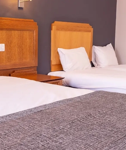 The interior hotel family bed bedroom with a king bed and two singles at the Brentwood.