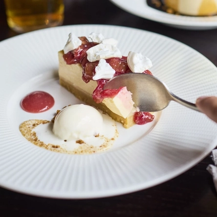 A Lifestyle image of a plated Rhubarb & Custard Cheesecake Mothers Day dish available at Metro venues.