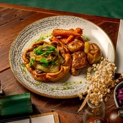 A plated Mushroom Galette with a range of sides on a wooden table.