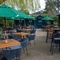 The exterior beer garden seating area of the Golden Hind in Cambridge, with shade umbrellas, string lights, and under cover seating areas.