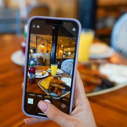 A woman taking a picture of food at a pub