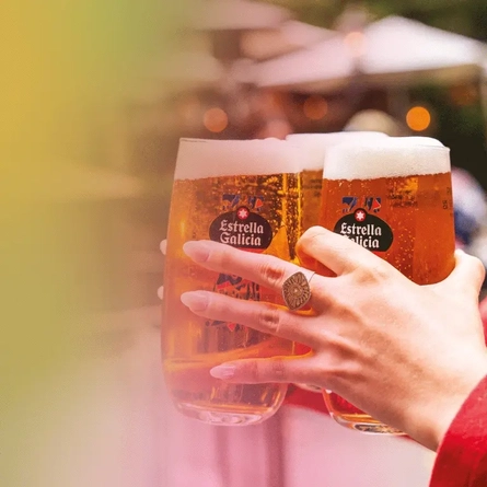 A mobile banner showing 3 pints of Estrella Galicia being carried by a person to advertise a Estrella Galicia Summer Sessions event taking place at Metro venues.