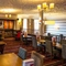 Interior dining area of a pub with a fireplace.