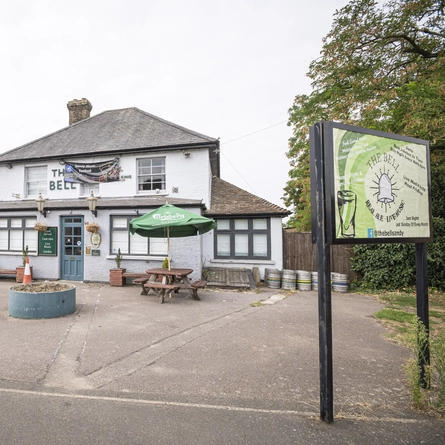 The exterior facade and car park with venue signage at The Bell.