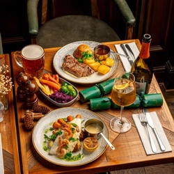 Plated main meals on a festive decorated wooden table.