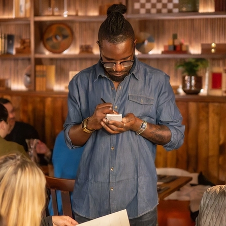 a waiter of The Bishop pub taking orders at the tables