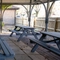 The exterior undercover beer garden seating area at the Clocktower in Milton Keynes, with wooden picnic tables.