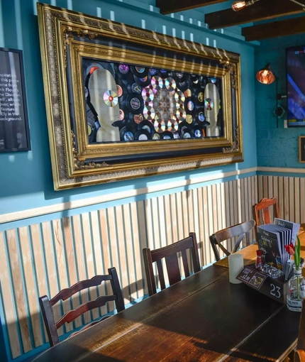 Small room with a table for dining with discs framed for decor