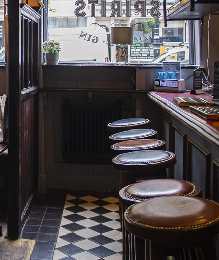 The interior seating area and bar of The Plumbers Arms in Belgravia.