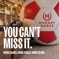 A banner promoting the new football season at Hungry Horse venues. The banner shows an interior of a Hungry Horse-branded sports bar featuring a giant football-shaped wall installation beside the bar. Large white text reads “YOU CAN’T MISS IT.” with smaller text underneath stating “MORE GAMES. MORE GOALS. MORE GLORY.” A television screen showing a football match is visible in the background above beer taps and shelves of bottles.