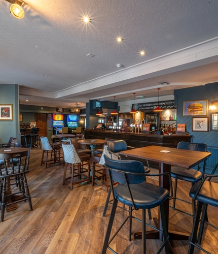 The interior bar and restaurant seating area with electronic pub games at The Old Red Lion.
