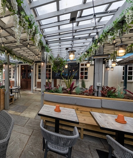 Exterior beer garden of a pub with a seating area.