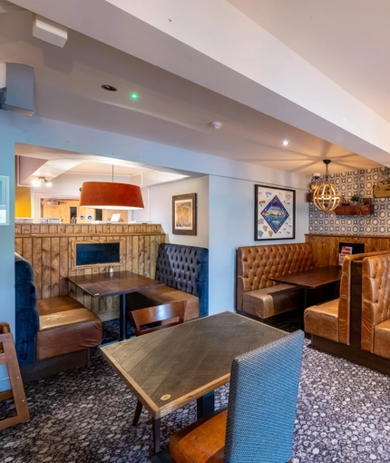 Interior dining area of a pub with TVs.