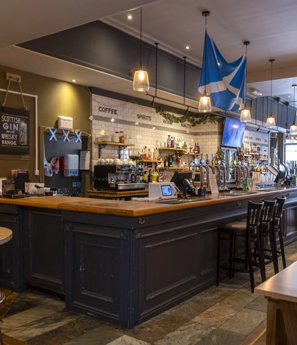Interior dining area of a pub with a TV and a bar.