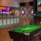 The interior games area at the Green Posts in Portsmouth, with two dartboards, a pool table, a fireplace, and two TVs on the walls.