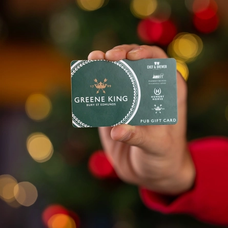 A man holding a few Greene King gift cards