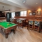 A pool table and slots machine next to some restaurant tables in The Brocklehurst Arms.