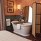 Hotel room with free standing roll top bath and large mirror