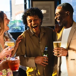 A group of people standing, enjoying various drinks.